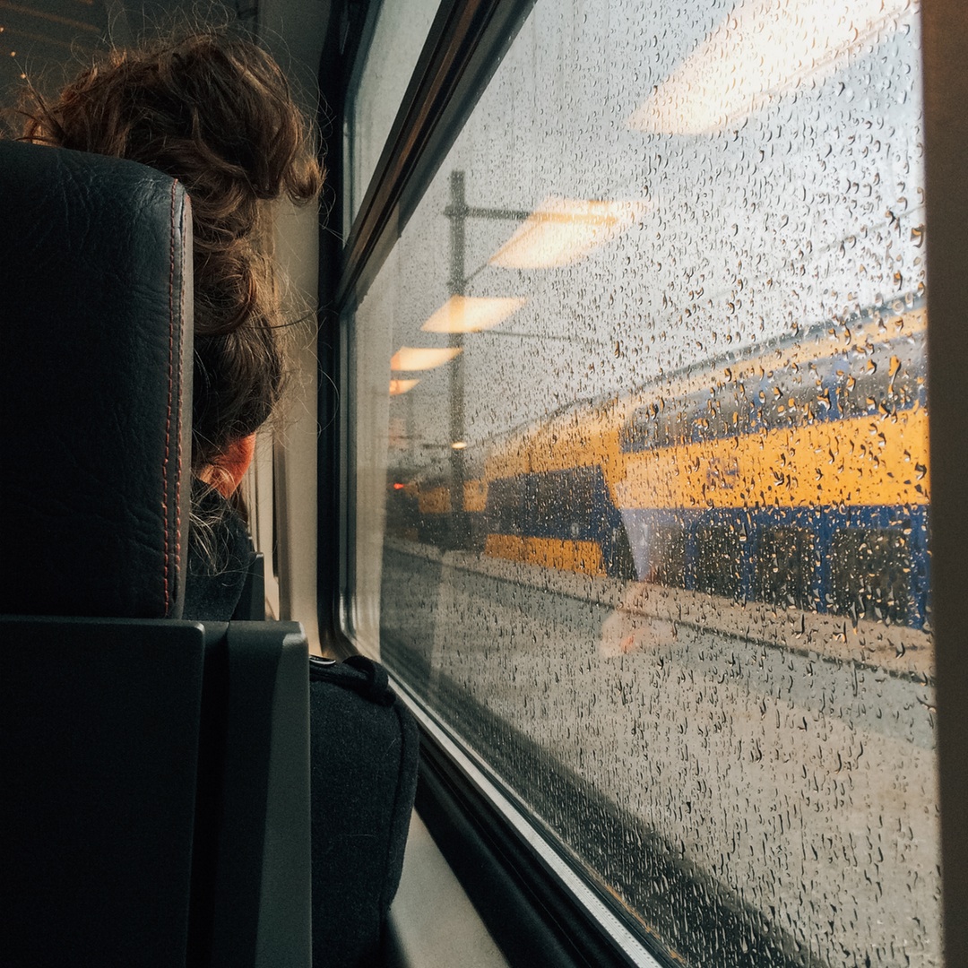 chica en tren lloviendo